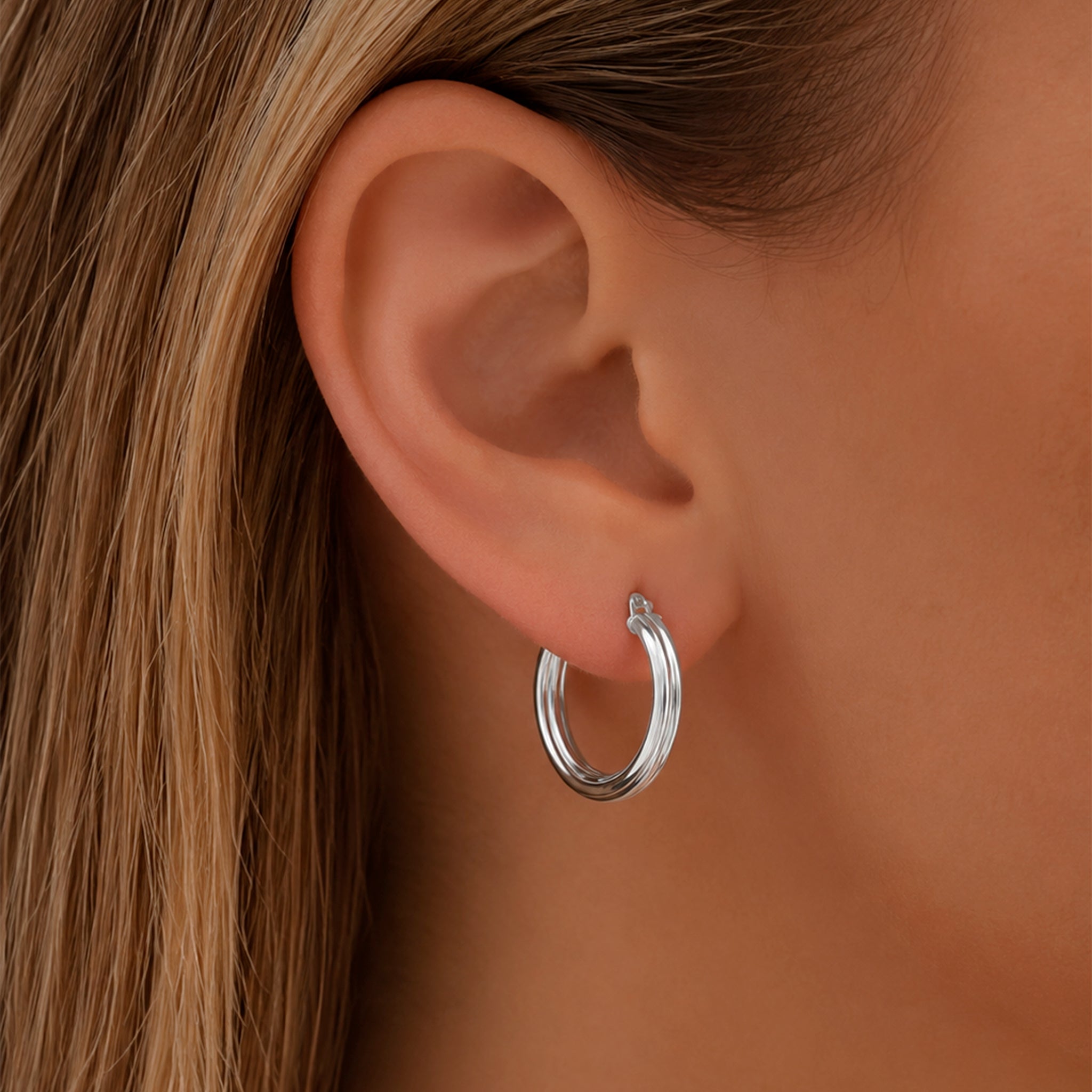 Modelo usando las Arracadas Brisa de plata .925 con diseño moderno y elegante.